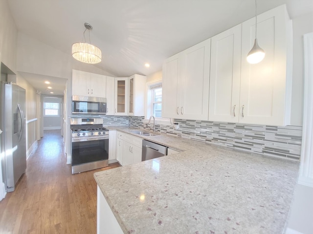 1747 E 92nd Pl, Chicago, IL 60617 - kitchen featuring appliances with stainless steel finishes, plenty of natural light, light stone countertops, white cabinetry, and vaulted ceiling