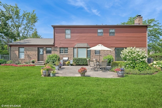 375 Sunset Dr, Northfield, IL 60093 - back of house featuring a chimney, a lawn, a patio, and brick siding