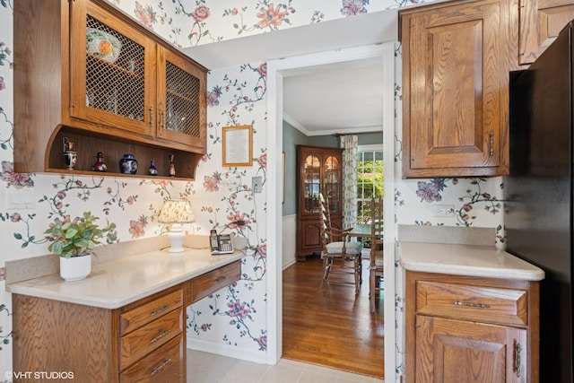 375 Sunset Dr, Northfield, IL 60093 - kitchen with wallpapered walls, freestanding refrigerator, ornamental molding, light countertops, and brown cabinetry
