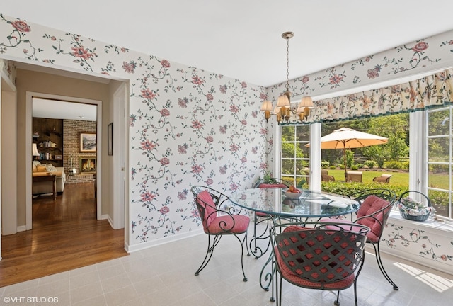 375 Sunset Dr, Northfield, IL 60093 - dining area with wallpapered walls, a chandelier, plenty of natural light, and a brick fireplace