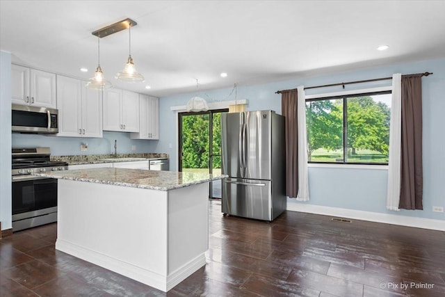 3920 Greenbay Dr, Hanover Park, IL 60133 - kitchen with appliances with stainless steel finishes, recessed lighting, white cabinetry, light stone counters, and decorative light fixtures