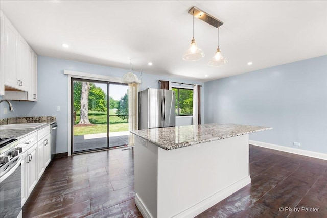 3920 Greenbay Dr, Hanover Park, IL 60133 - kitchen with stainless steel appliances, light stone countertops, a center island, white cabinetry, and dark wood-style floors