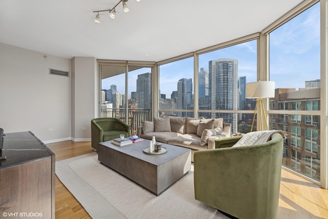 645 N Kingsbury St Unit 2002, Chicago, IL 60654 - living room with a view of skyline, floor to ceiling windows, wood finished floors, and track lighting