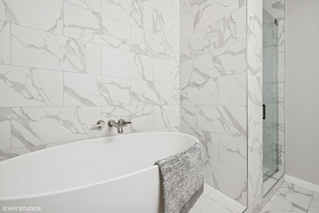 645 N Kingsbury St Unit 2002, Chicago, IL 60654 - full bathroom with marble look tiles, a freestanding tub, and a shower stall