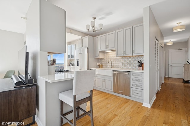 645 N Kingsbury St Unit 2002, Chicago, IL 60654 - kitchen with appliances with stainless steel finishes, light wood-style floors, light countertops, and decorative backsplash