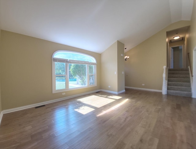 913 Dartmouth Ave, Matteson, IL 60443 - unfurnished room with vaulted ceiling, wood finished floors, a chandelier, and stairs