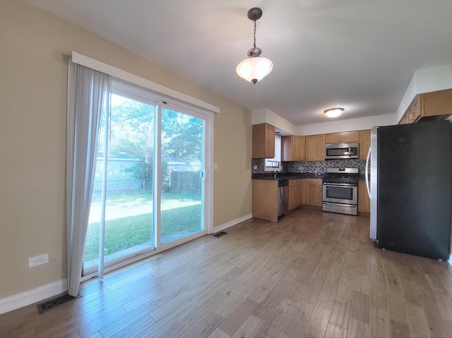 913 Dartmouth Ave, Matteson, IL 60443 - kitchen featuring stainless steel appliances, light wood-style floors, tasteful backsplash, and dark countertops