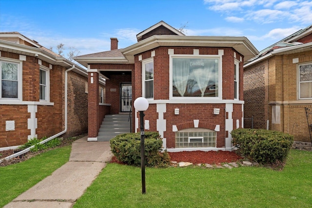 8214 S Paxton Ave, Chicago, IL 60617 - view of front of home featuring brick siding, a front yard, and a chimney