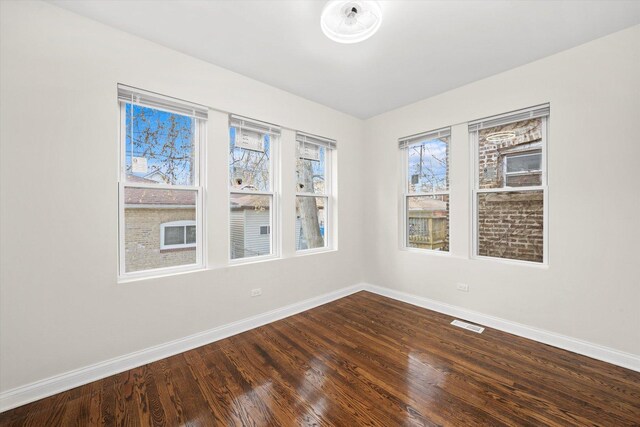 8214 S Paxton Ave, Chicago, IL 60617 - spare room featuring baseboards and dark wood-type flooring