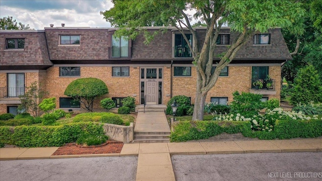 208 Kenston Ct Unit 208, Geneva, IL 60134 - view of front of home with mansard roof, a shingled roof, and brick siding
