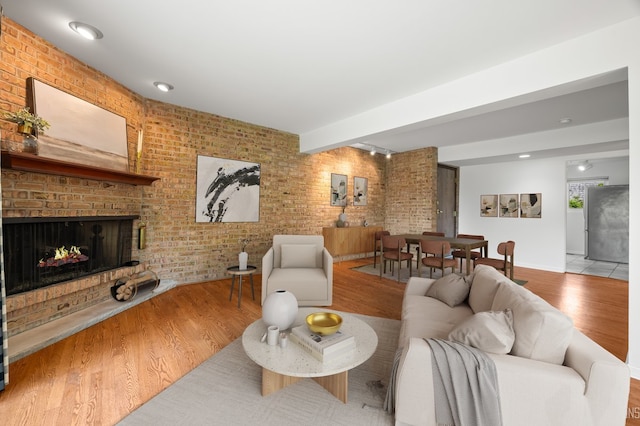 208 Kenston Ct Unit 208, Geneva, IL 60134 - living room featuring brick wall, wood finished floors, and a fireplace