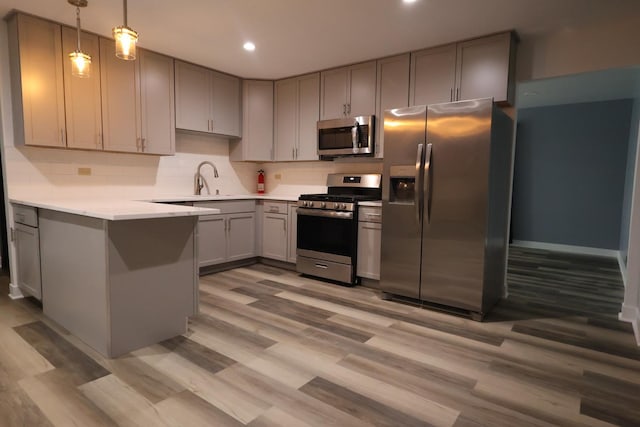 8818 Lori Ln, Orland Park, IL 60462 - kitchen featuring stainless steel appliances, gray cabinets, a peninsula, light wood-style floors, and recessed lighting