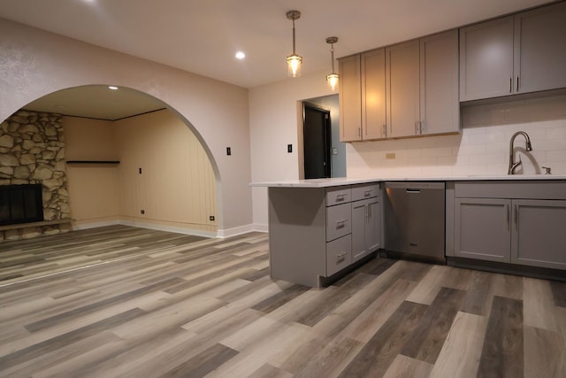 8818 Lori Ln, Orland Park, IL 60462 - kitchen with stainless steel dishwasher, gray cabinetry, a peninsula, arched walkways, and decorative backsplash