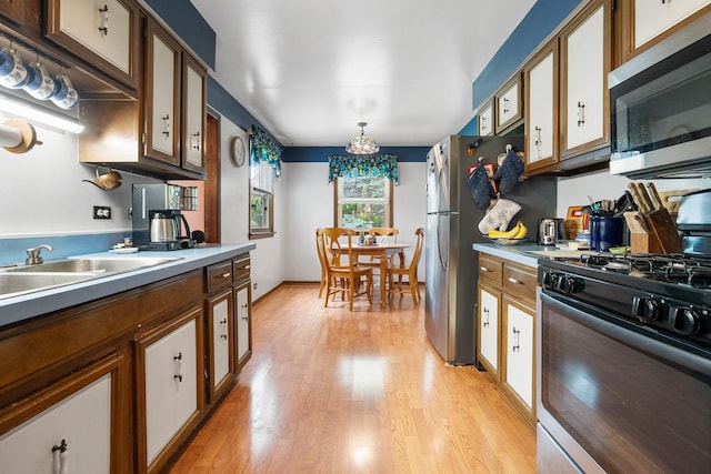 9108 Windsor Dr, Palos Hills, IL 60465 - kitchen featuring stainless steel appliances, light wood-style flooring, light countertops, a chandelier, and brown cabinetry