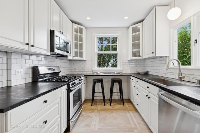 2539 Marcy Ave, Evanston, IL 60201 - kitchen with stainless steel appliances, dark countertops, white cabinetry, glass insert cabinets, and recessed lighting