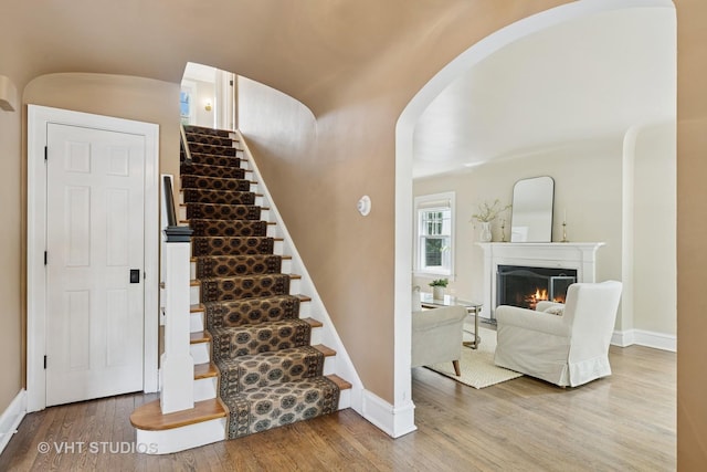 2539 Marcy Ave, Evanston, IL 60201 - stairs with arched walkways, wood finished floors, and a lit fireplace
