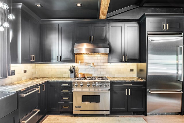 400 S Rose Ave, Park Ridge, IL 60068 - kitchen featuring high end appliances, under cabinet range hood, dark cabinets, light stone countertops, and tasteful backsplash