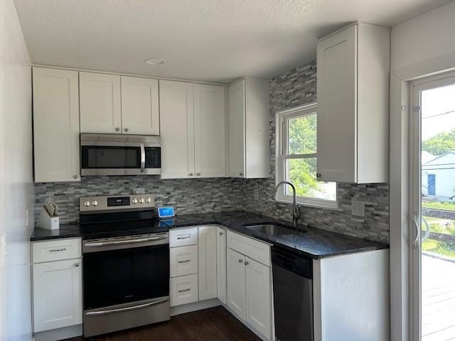 110 Shady Ln, Dixon, IL 61021 - kitchen with appliances with stainless steel finishes, dark countertops, and white cabinetry