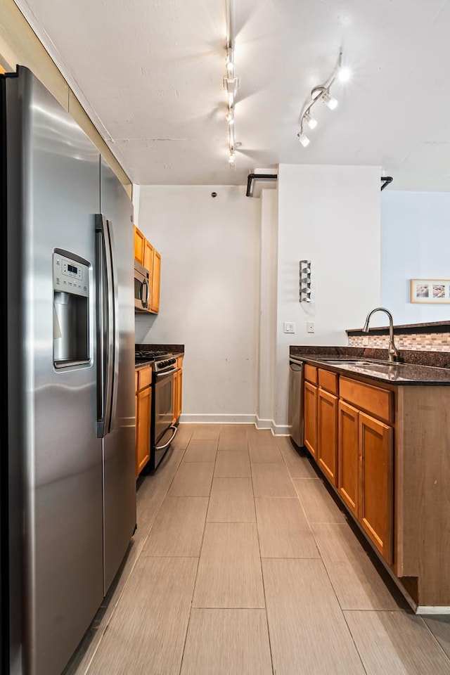 1305 S Michigan Ave Unit 807, Chicago, IL 60605 - kitchen featuring appliances with stainless steel finishes, brown cabinetry, dark stone counters, and a peninsula