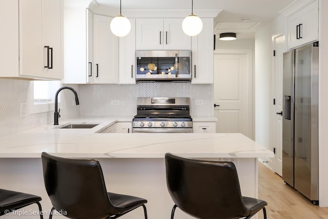 7939 Neva Ave, Burbank, IL 60459 - kitchen with stainless steel appliances, a peninsula, white cabinets, light stone countertops, and pendant lighting