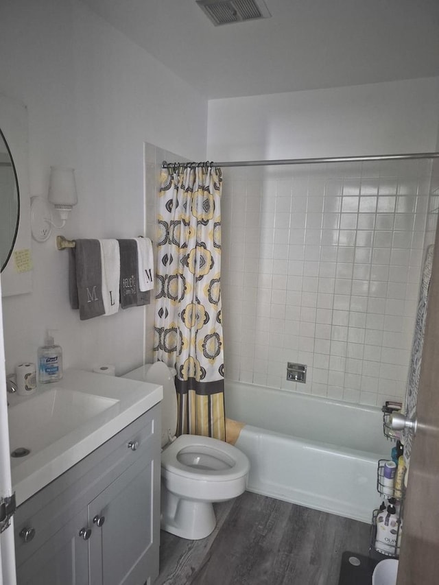bathroom featuring wood finished floors, vanity, and shower / bathtub combination with curtain