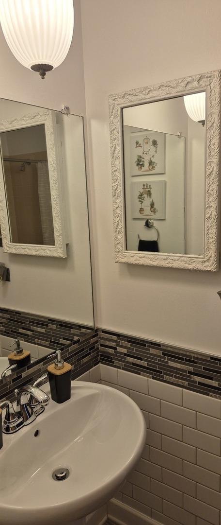 bathroom featuring a wainscoted wall and tile walls