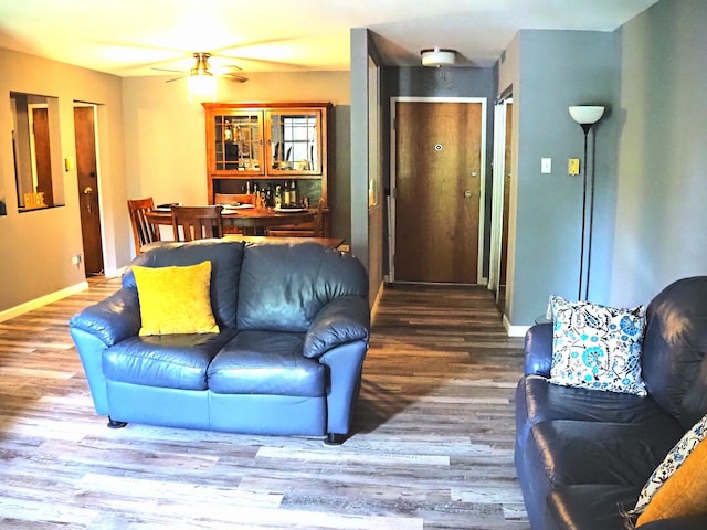 living room with wood finished floors and ceiling fan