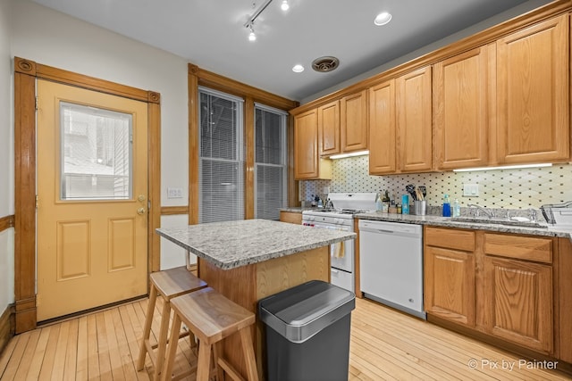 3516 N Reta Ave, Chicago, IL 60657 - kitchen featuring white appliances, light wood-type flooring, decorative backsplash, and a kitchen island