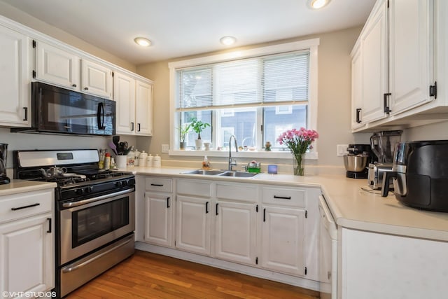 609 N 7th St, Dekalb, IL 60115 - kitchen featuring gas stove, black microwave, white cabinetry, light countertops, and recessed lighting