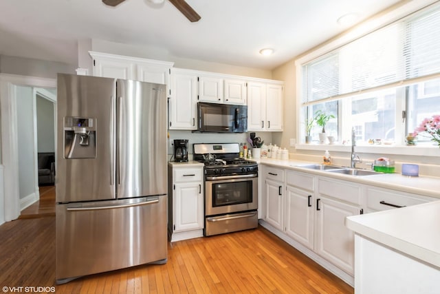 609 N 7th St, Dekalb, IL 60115 - kitchen with appliances with stainless steel finishes, white cabinets, light countertops, and light wood-type flooring