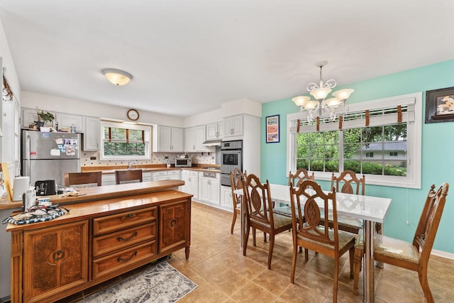 1207 W Busse Ave, Mount Prospect, IL 60056 - dining space featuring a chandelier and light tile patterned floors