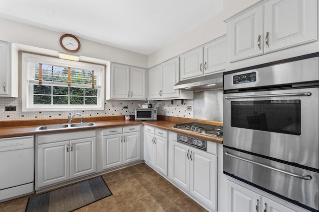 1207 W Busse Ave, Mount Prospect, IL 60056 - kitchen featuring appliances with stainless steel finishes, a warming drawer, under cabinet range hood, white cabinets, and backsplash