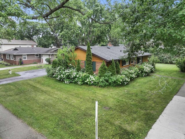 1207 W Busse Ave, Mount Prospect, IL 60056 - view of side of property with a lawn, brick siding, driveway, and a chimney