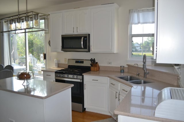 4355 Barharbor Dr, Lake In The Hills, IL 60156 - kitchen with appliances with stainless steel finishes, white cabinetry, light stone counters, and pendant lighting