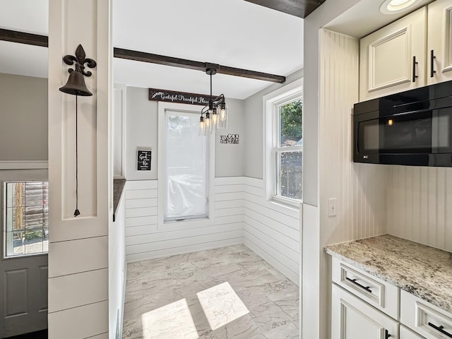 307 Christie St, Ottawa, IL 61350 - kitchen with black microwave, marble finish floors, wainscoting, light stone countertops, and a chandelier