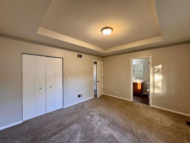 17303 Kedzie Ave, Hazel Crest, IL 60429 - unfurnished bedroom with a tray ceiling, carpet flooring, ensuite bathroom, and a closet