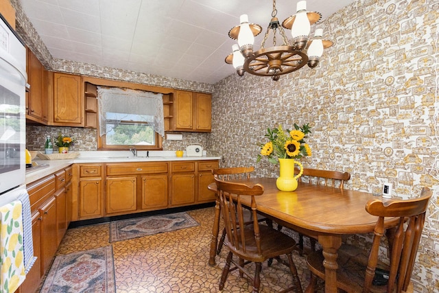1723 N Raynor Ave, Crest Hill, IL 60403 - kitchen featuring open shelves, a chandelier, light countertops, brown cabinets, and backsplash