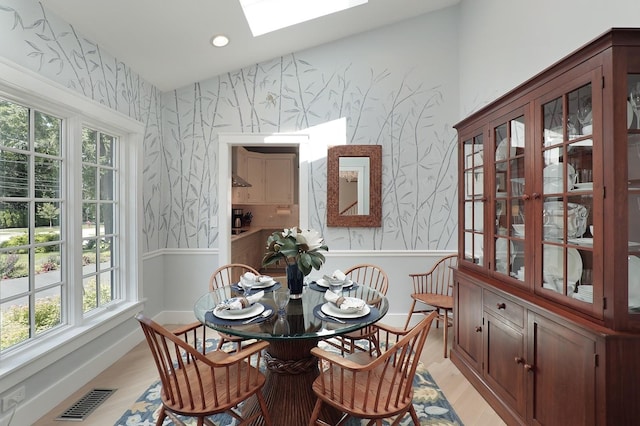 100 Beach Rd, Glencoe, IL 60022 - dining room featuring wallpapered walls, a skylight, wainscoting, and light wood-style floors