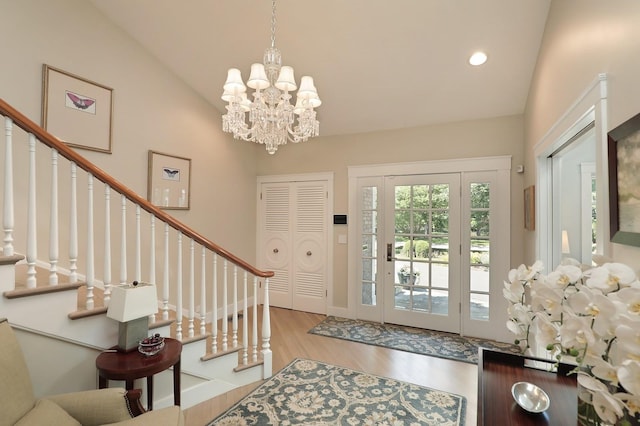 100 Beach Rd, Glencoe, IL 60022 - foyer entrance featuring wood finished floors, lofted ceiling, stairway, a chandelier, and recessed lighting