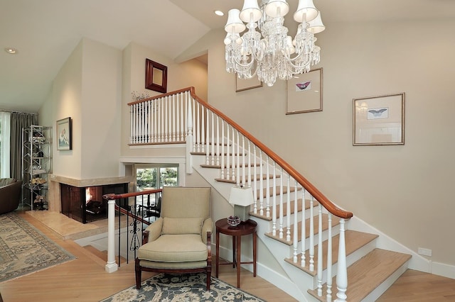 100 Beach Rd, Glencoe, IL 60022 - staircase featuring wood finished floors, a chandelier, a multi sided fireplace, recessed lighting, and high vaulted ceiling