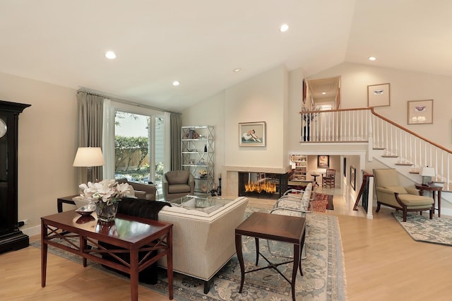 100 Beach Rd, Glencoe, IL 60022 - living area featuring a multi sided fireplace, light wood-type flooring, recessed lighting, stairway, and high vaulted ceiling