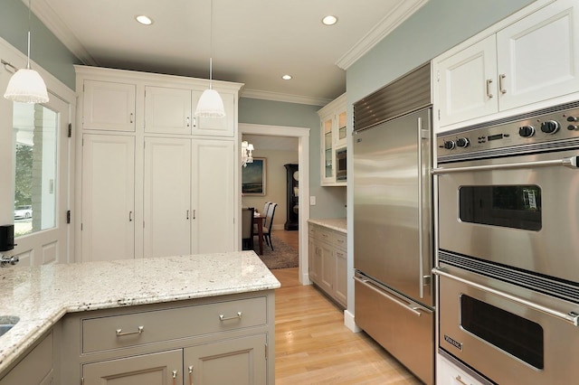 100 Beach Rd, Glencoe, IL 60022 - kitchen featuring stainless steel appliances, crown molding, decorative light fixtures, light wood-style flooring, and light stone counters