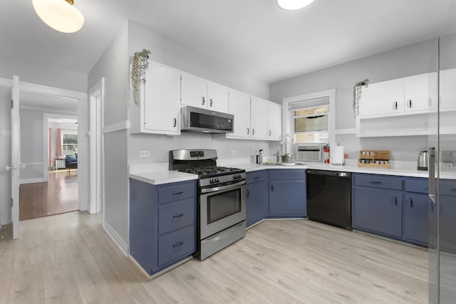 317 N Marion St, Oak Park, IL 60302 - kitchen featuring stainless steel appliances, blue cabinets, and light wood finished floors