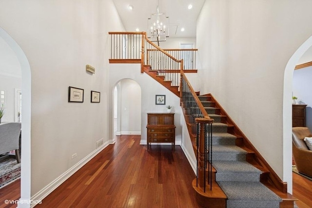 3967 Garden Ave, Western Springs, IL 60558 - staircase with arched walkways, wood finished floors, a chandelier, a high ceiling, and recessed lighting