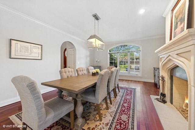 3967 Garden Ave, Western Springs, IL 60558 - dining space with a fireplace, a chandelier, arched walkways, ornamental molding, and wood finished floors