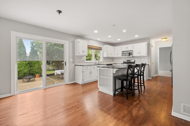 2311 Tremont Ave, Aurora, IL 60502 - kitchen featuring appliances with stainless steel finishes, white cabinets, open shelves, decorative backsplash, and recessed lighting