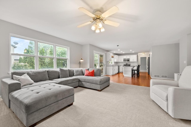 2311 Tremont Ave, Aurora, IL 60502 - living room with light carpet, ceiling fan, recessed lighting, and light wood-type flooring
