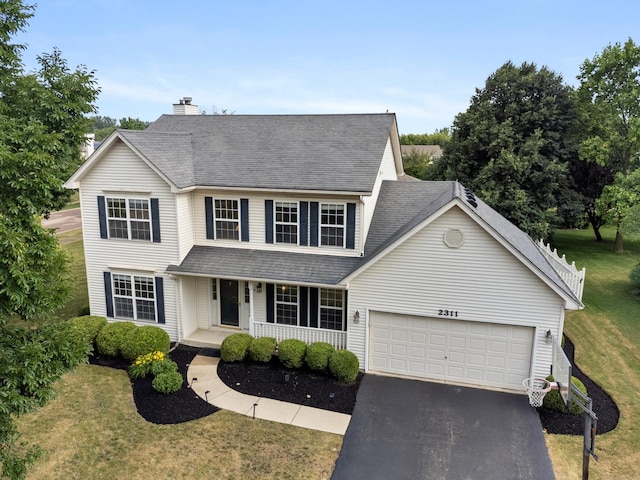 2311 Tremont Ave, Aurora, IL 60502 - traditional-style house with a porch, asphalt driveway, an attached garage, and a front lawn