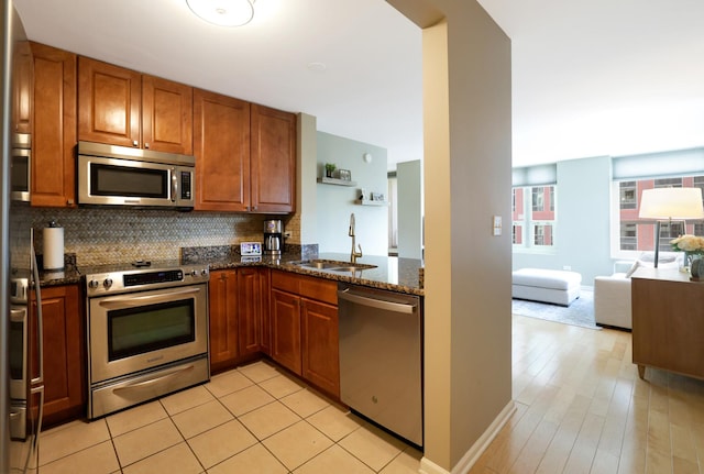 345 N La Salle Dr Unit 1010, Chicago, IL 60654 - kitchen with stainless steel appliances, brown cabinetry, dark stone countertops, decorative backsplash, and open floor plan