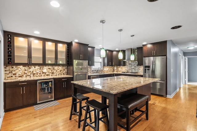 3850 Seaview Dr, Hanover Park, IL 60133 - kitchen with stainless steel appliances, beverage cooler, a breakfast bar area, dark brown cabinetry, and light wood-style floors